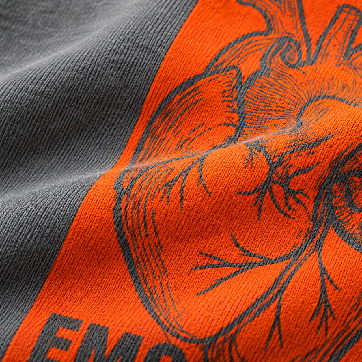 Nahaufnahme des orangefarbenen Split-Block-Prints auf grauem Sweatstoff